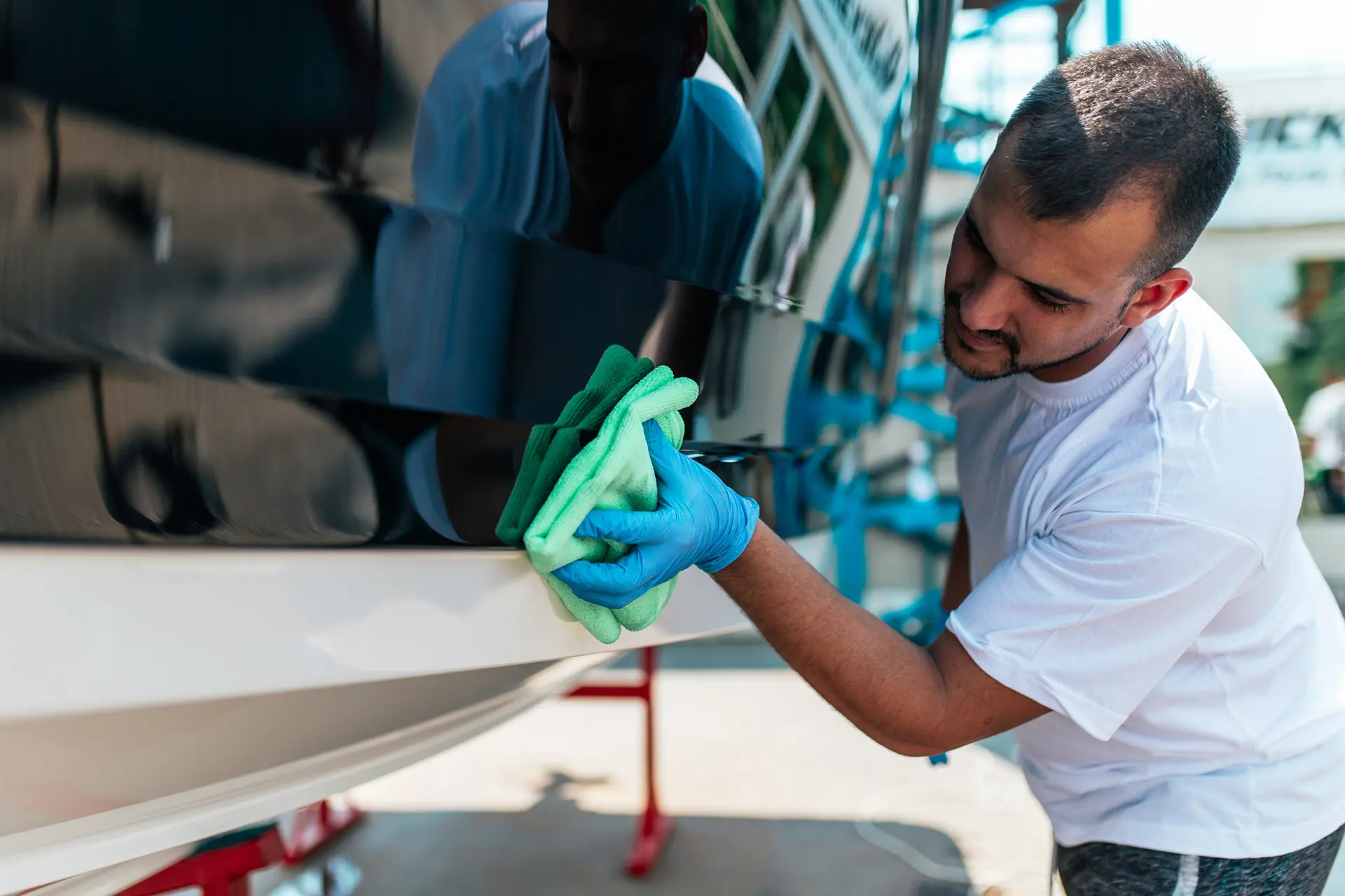 Man cleaning a yacht in Deerfield Beach as a part of routine yacht maintenance at dry dock